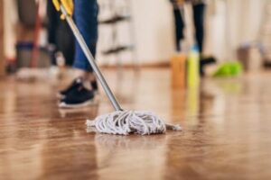a woman removing water on laminate floor