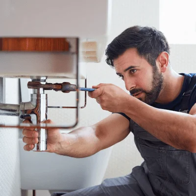 man repairing burst pipe