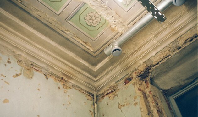 Deteriorated ceiling with peeling paint and visible moisture damage — the consequence of AC condensate water that went undetected in an attic for more than 48 hours before professional drying equipment was deployed
