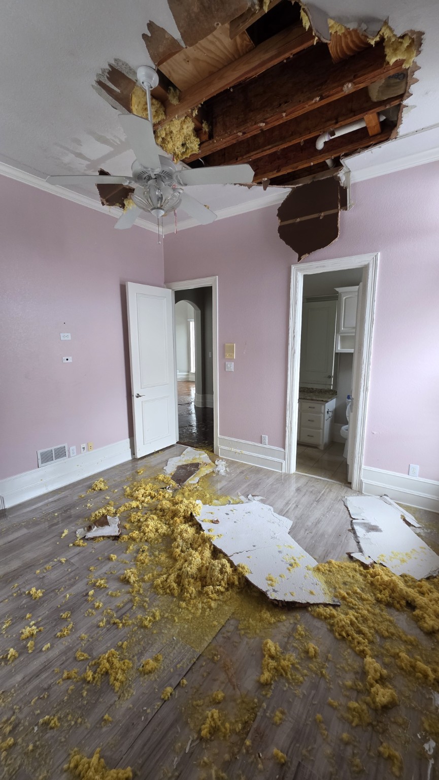 Water-damaged ceiling with exposed framing and fallen insulation