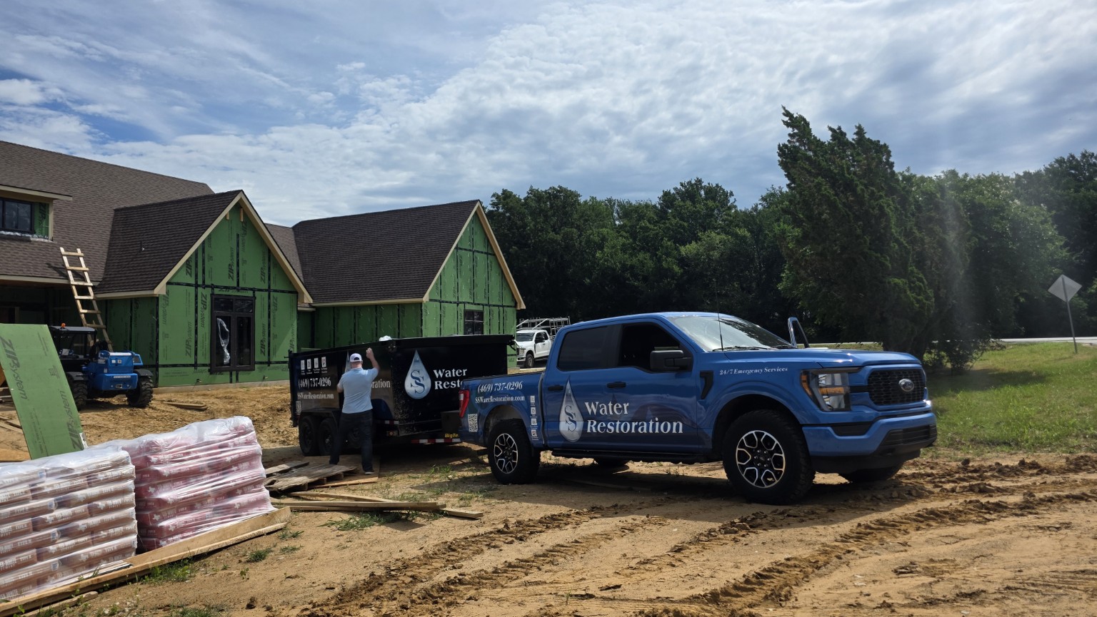 SS Water Restoration truck and equipment trailer at a job site