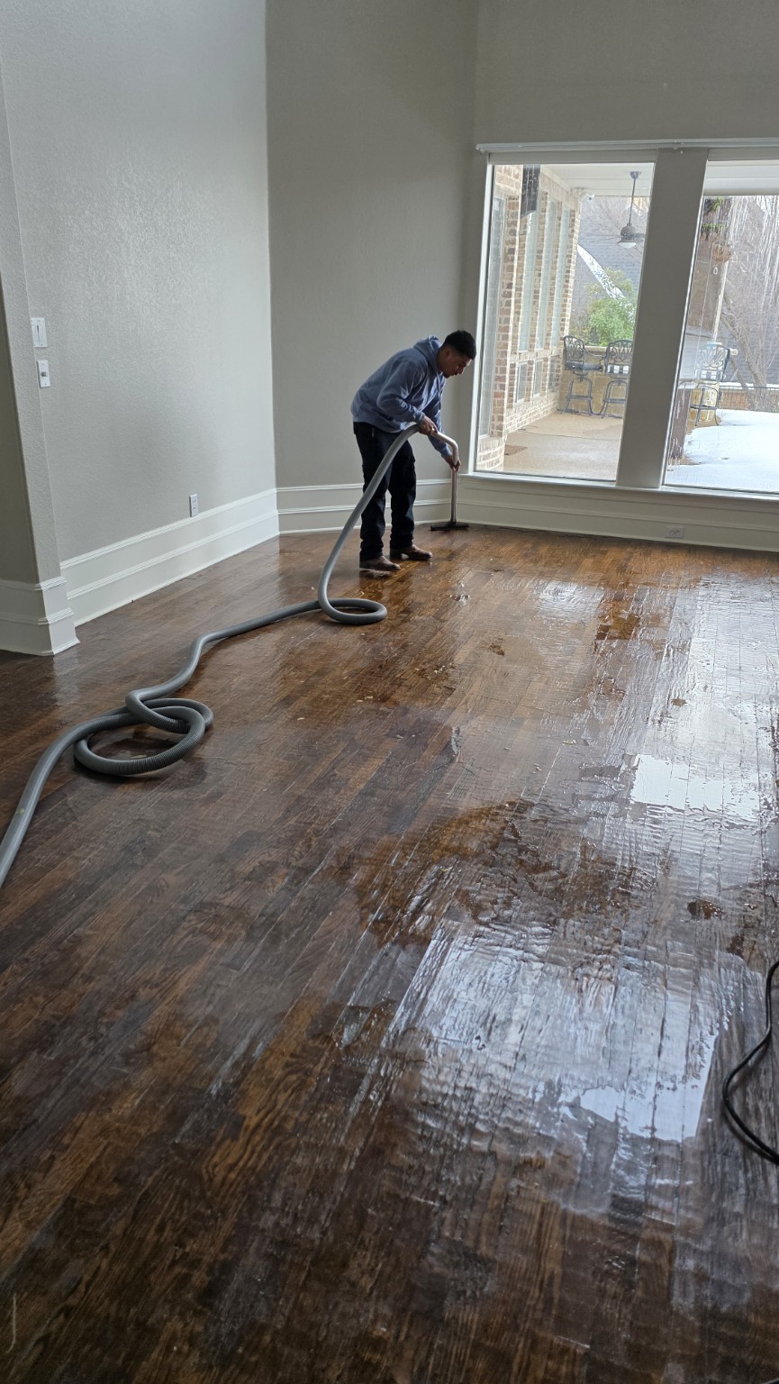 Technician extracting standing water from a hardwood floor
