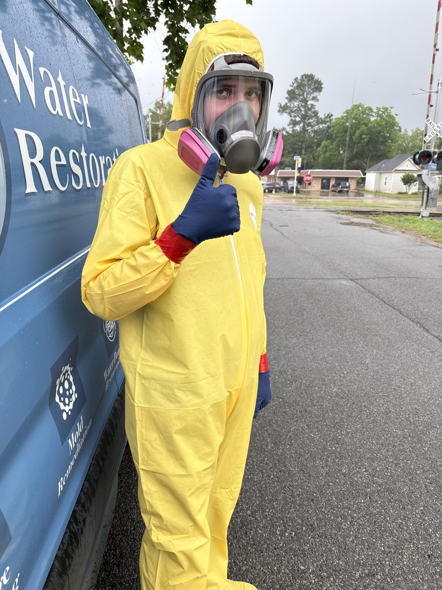 SS Water Restoration technician wearing protective coveralls and a respirator