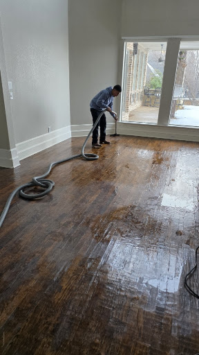 Technician extracting standing water from a hardwood floor